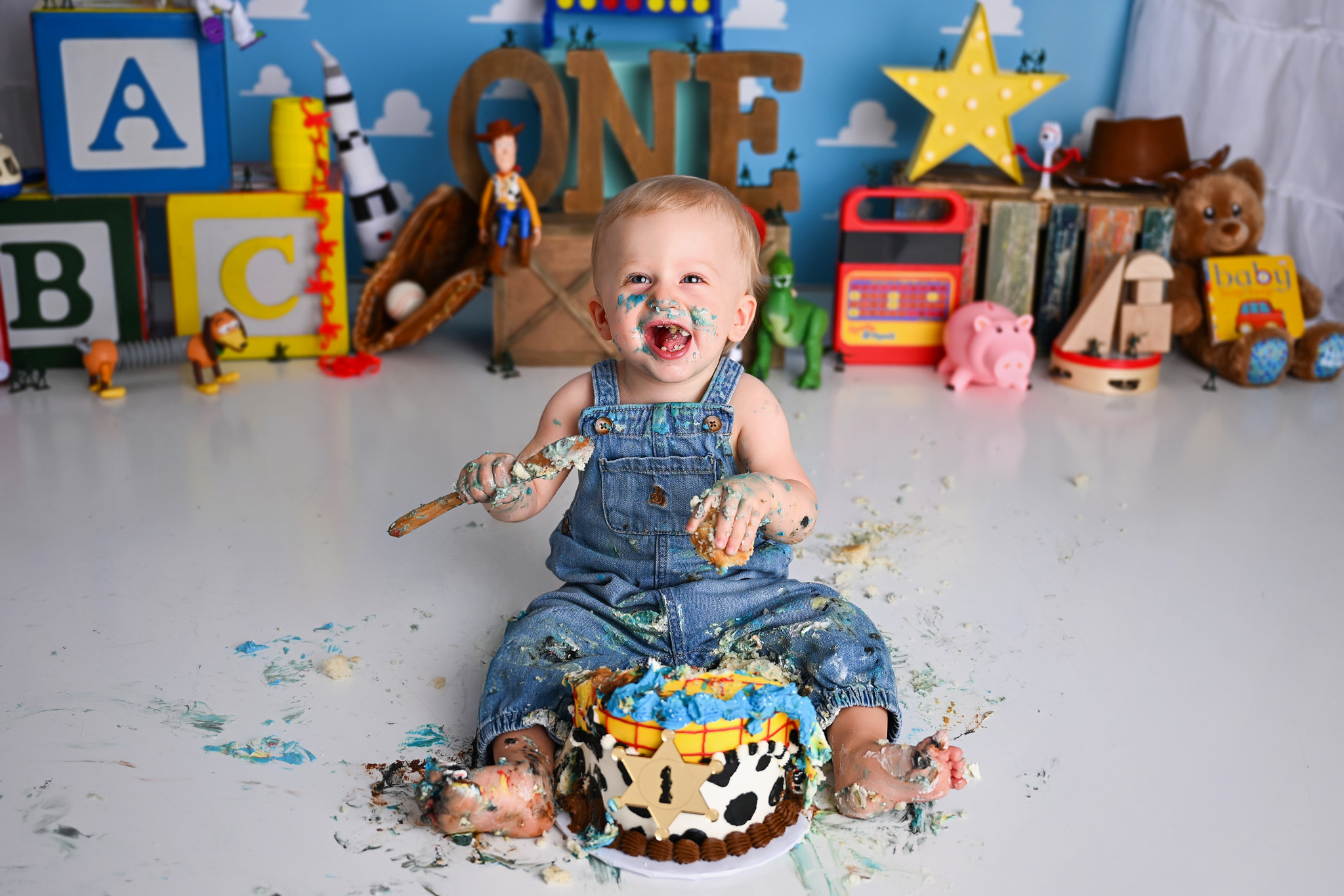 One year baby laugning eating a cake
