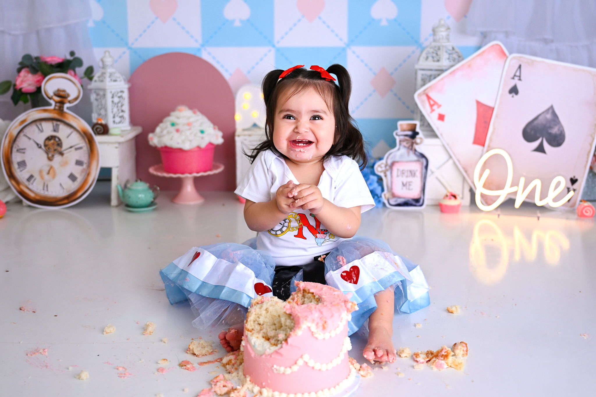 One year old baby celebrating a cake smash session eating a cake