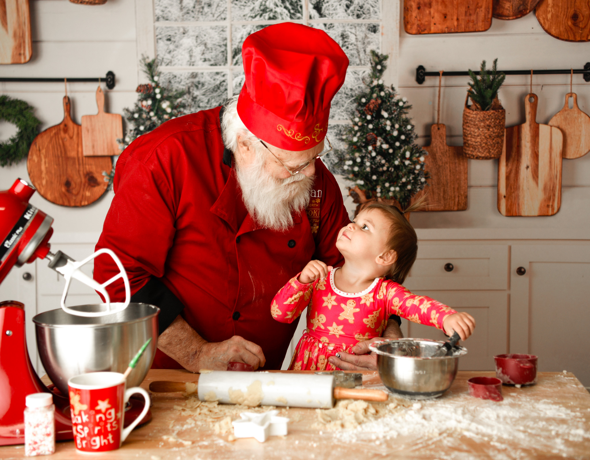 Santa Claus cooking with a young boy smiling