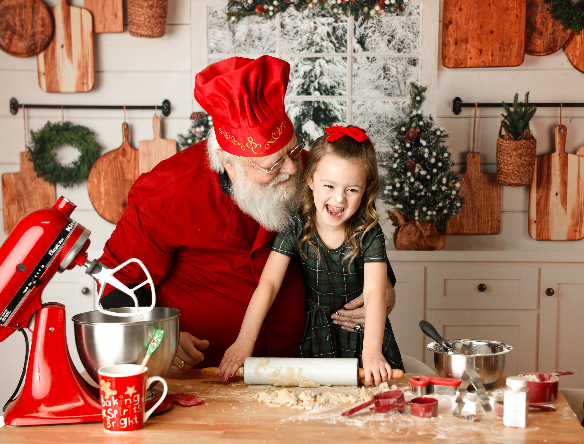 Santa Claus cooking with a young girl smiling