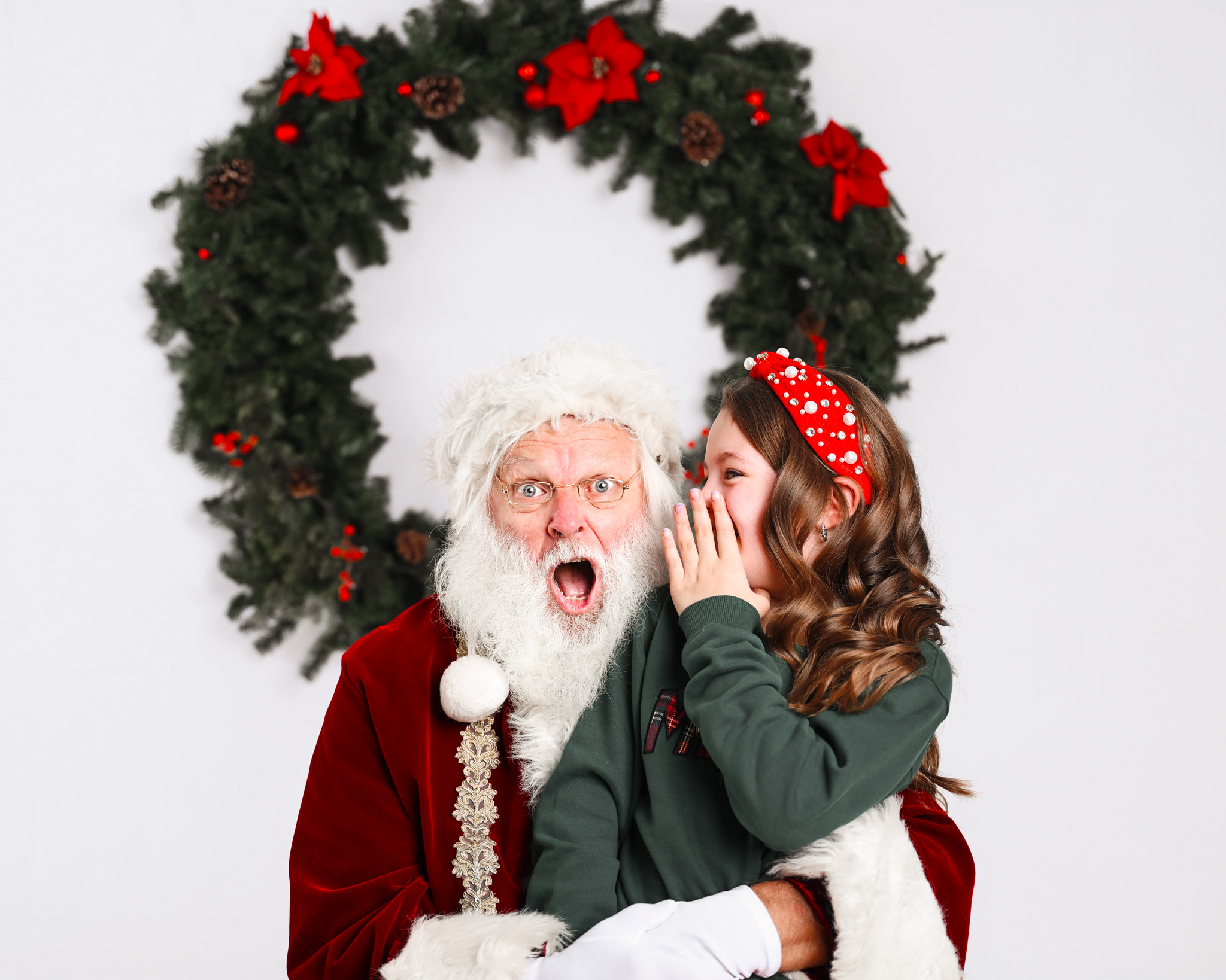 Santa Claus hearing a secret and surpised by a young girl