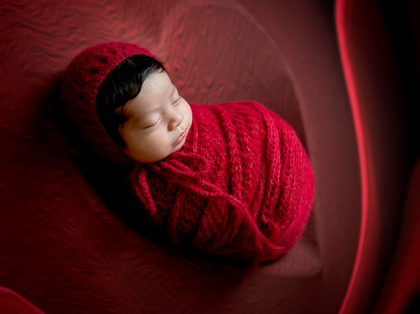 Newborn baby wrapped in soft neutral textiles