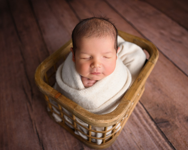 Newborn baby sleeping peacefully in a basket