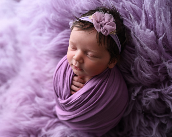 Newborn baby resting in a styled basket